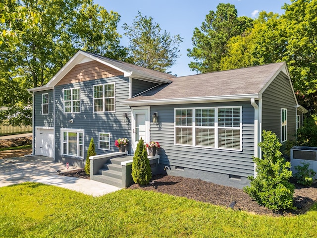 tri-level home with a front lawn, crawl space, and an attached garage