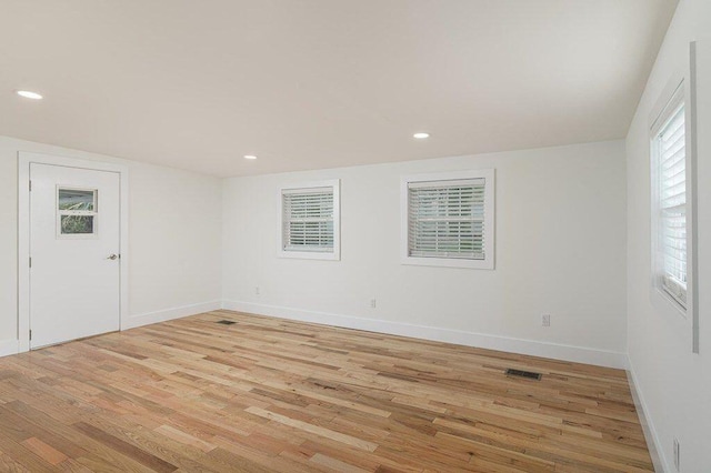 empty room featuring recessed lighting, light wood-type flooring, and baseboards