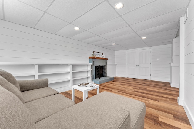 living room featuring a brick fireplace, wood finished floors, and recessed lighting