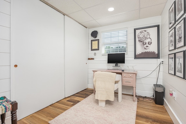 office space with a drop ceiling and wood finished floors