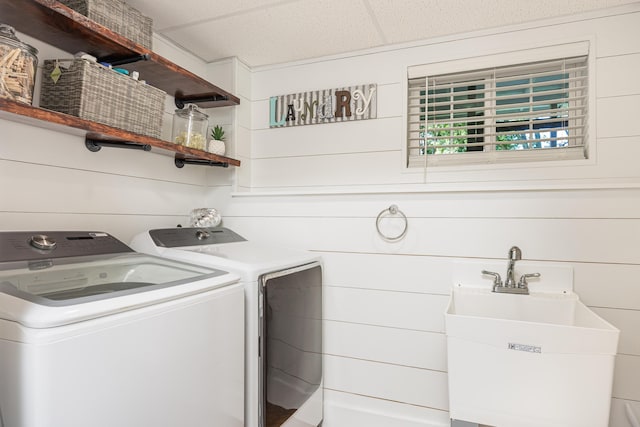 clothes washing area with laundry area, a sink, and washer and dryer