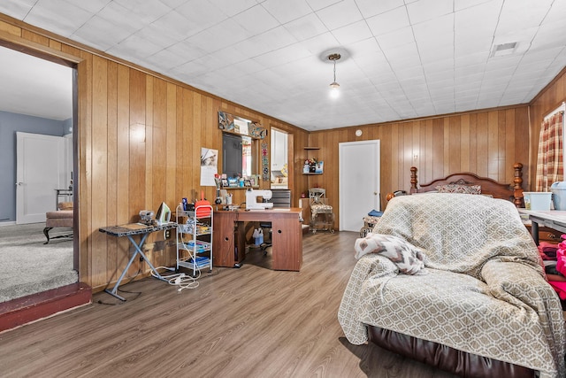 bedroom with hardwood / wood-style flooring and wood walls