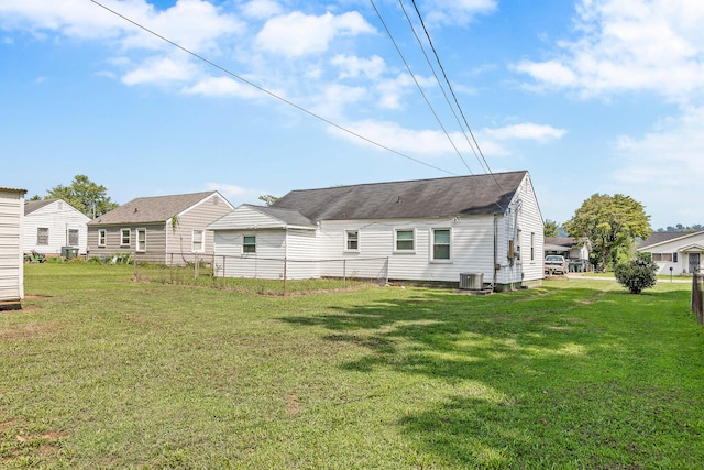 back of property featuring cooling unit and a yard