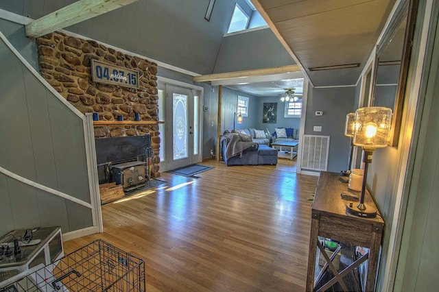 living room with hardwood / wood-style flooring, ceiling fan, and vaulted ceiling