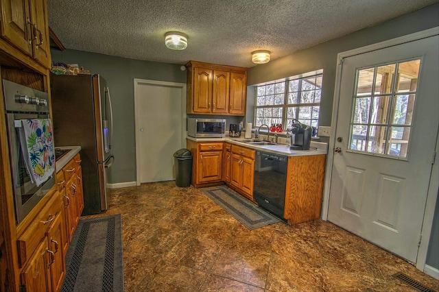 kitchen featuring stainless steel appliances, sink, and a textured ceiling