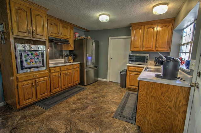 kitchen with stainless steel appliances and a textured ceiling