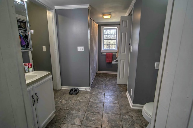 bathroom with vanity, crown molding, and toilet