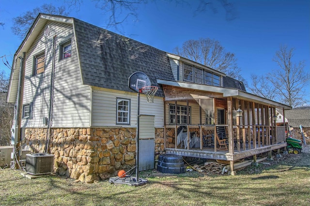 rear view of property with central AC and a yard