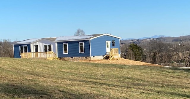 rear view of house with a mountain view and a lawn