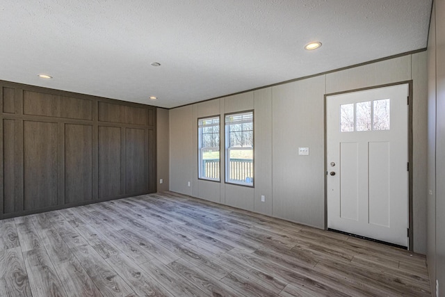 entryway featuring a healthy amount of sunlight, a textured ceiling, and light wood-type flooring