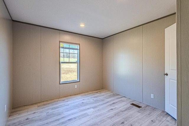 unfurnished room featuring light hardwood / wood-style flooring and ornamental molding