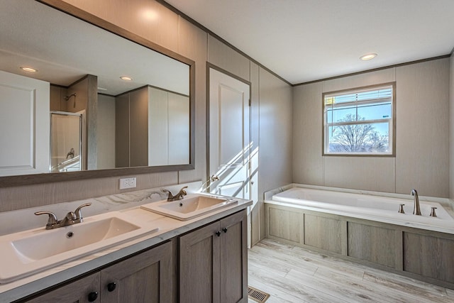 bathroom with hardwood / wood-style flooring, shower with separate bathtub, and vanity