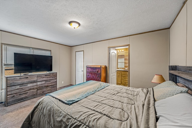 bedroom featuring ensuite bathroom, a textured ceiling, ornamental molding, carpet flooring, and a closet