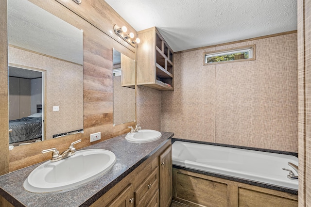 bathroom with vanity, a textured ceiling, and a bathing tub