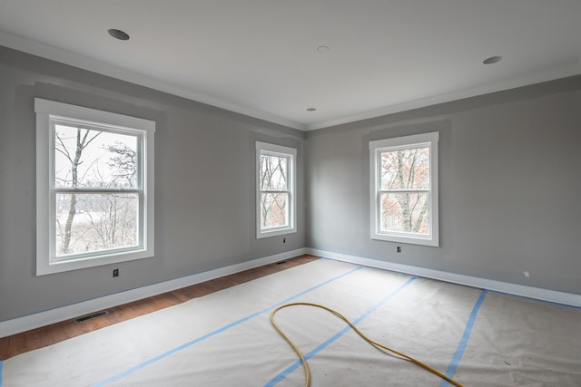 empty room with wood-type flooring and ornamental molding