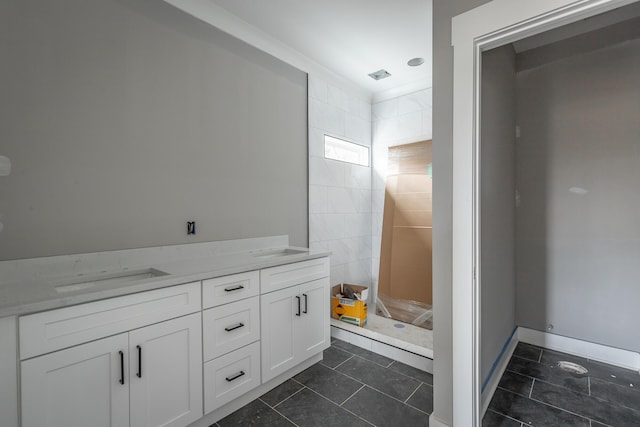 bathroom with tile patterned floors, vanity, and a tile shower