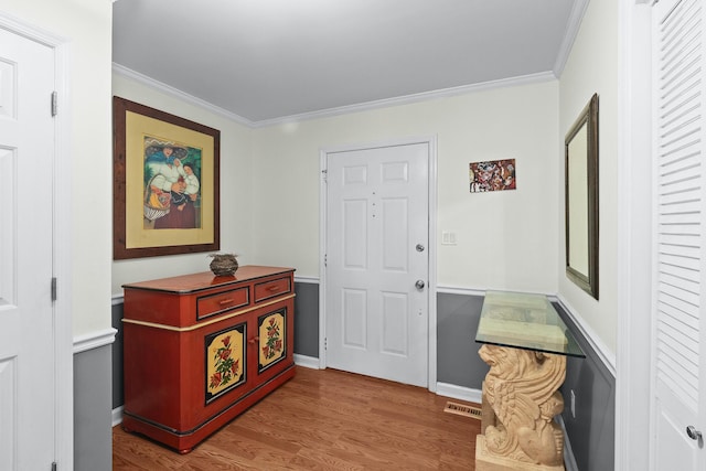 entryway featuring hardwood / wood-style flooring and ornamental molding