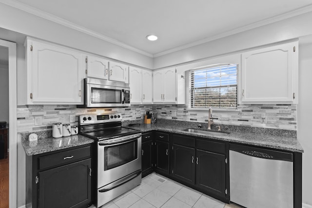 kitchen with appliances with stainless steel finishes, sink, decorative backsplash, and white cabinets