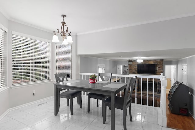 tiled dining space with a notable chandelier, crown molding, and a fireplace