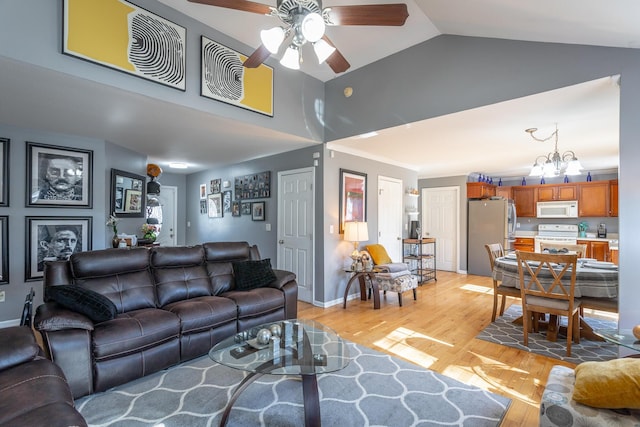 living room featuring high vaulted ceiling, ceiling fan with notable chandelier, and light hardwood / wood-style floors