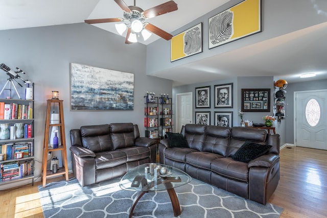 living room with vaulted ceiling, ceiling fan, and light wood-type flooring