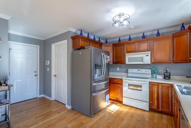 kitchen with ornamental molding, appliances with stainless steel finishes, sink, and light hardwood / wood-style floors