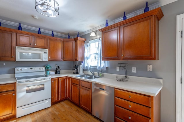 kitchen featuring sink, crown molding, decorative light fixtures, light hardwood / wood-style flooring, and white appliances