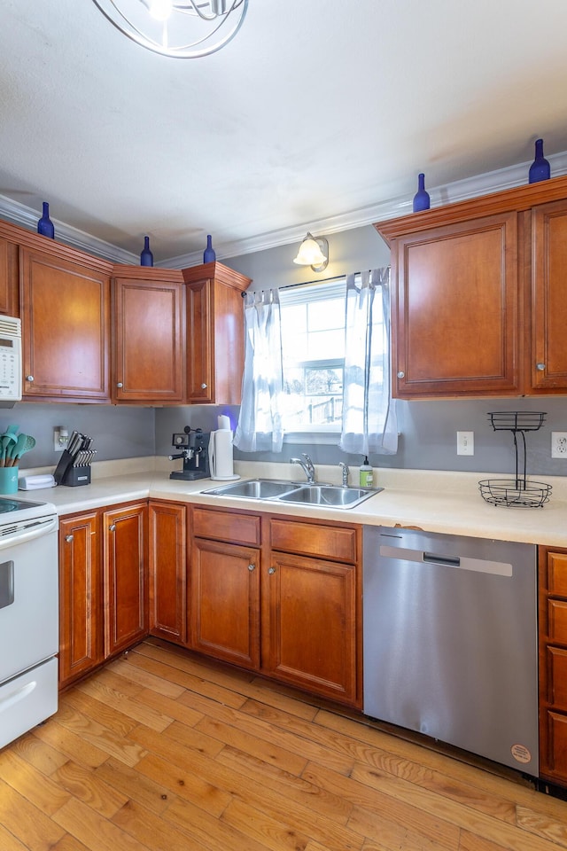 kitchen with sink, white appliances, ornamental molding, and light hardwood / wood-style floors