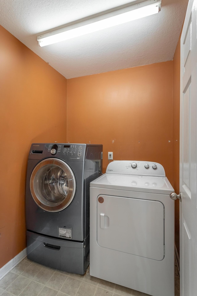 laundry room featuring washer and dryer and light tile patterned floors