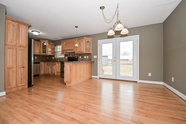 kitchen featuring stainless steel electric range, hanging light fixtures, backsplash, plenty of natural light, and a notable chandelier