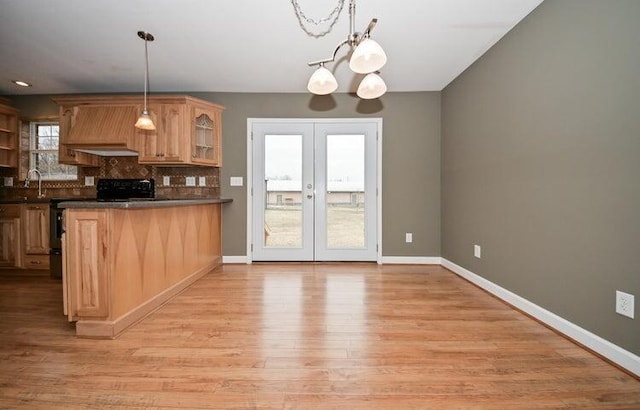 kitchen with decorative backsplash, light wood-type flooring, hanging light fixtures, and electric range