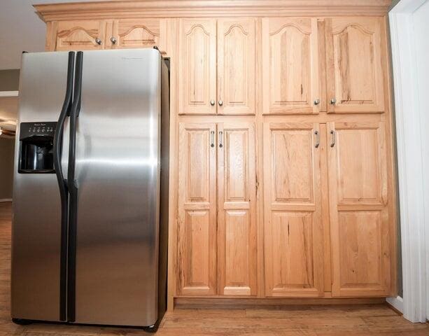 kitchen featuring light hardwood / wood-style flooring, stainless steel fridge, and light brown cabinets