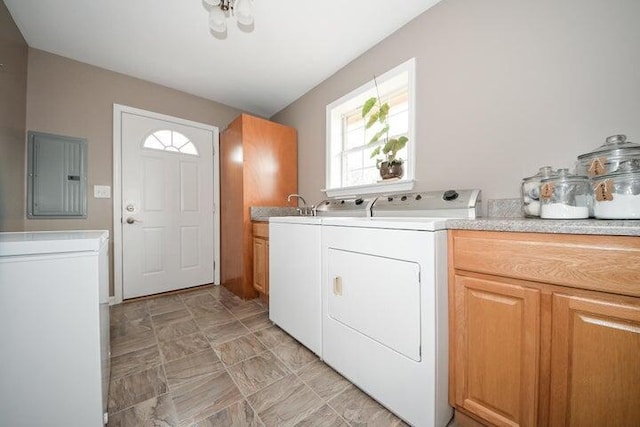 washroom featuring cabinets, electric panel, sink, and washer and dryer