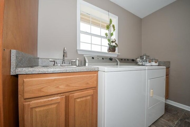 clothes washing area with cabinets, washing machine and dryer, and sink