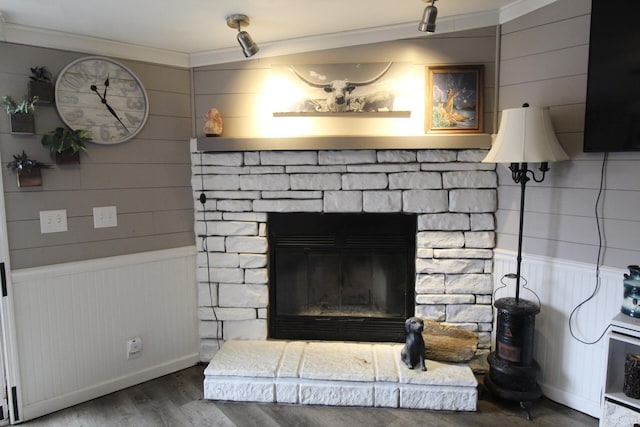 interior details featuring hardwood / wood-style flooring, a stone fireplace, and crown molding