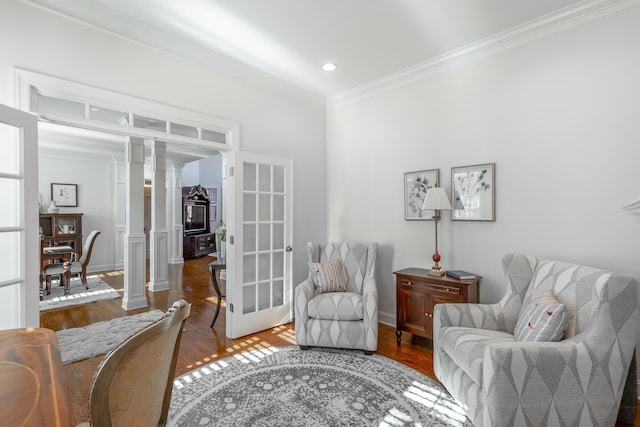 sitting room with crown molding, hardwood / wood-style flooring, and decorative columns