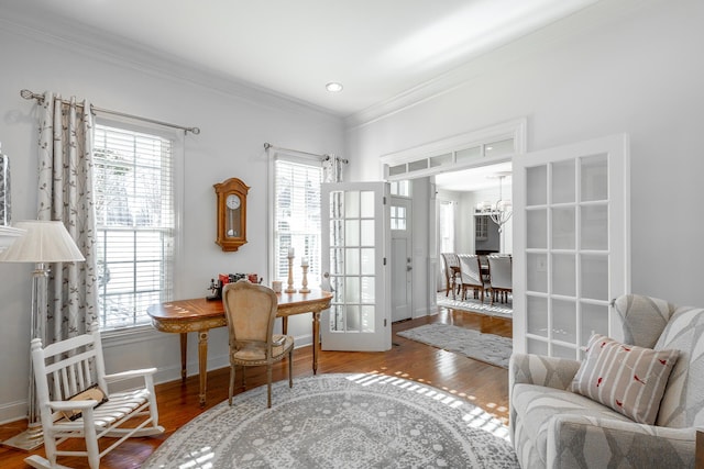 living area featuring hardwood / wood-style floors, crown molding, and plenty of natural light