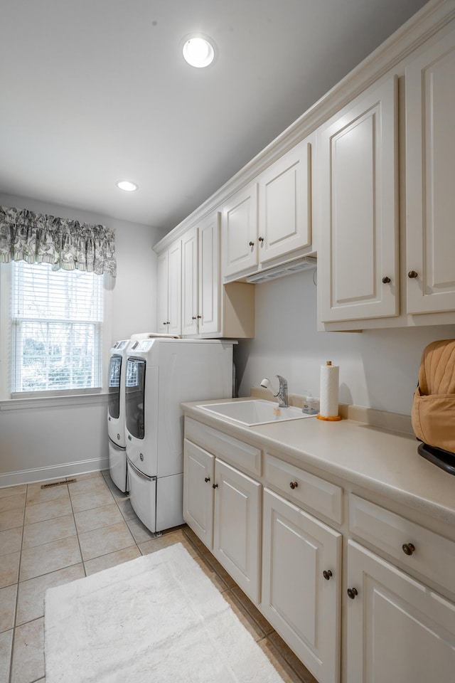 laundry room featuring cabinets, washing machine and dryer, sink, and light tile patterned flooring