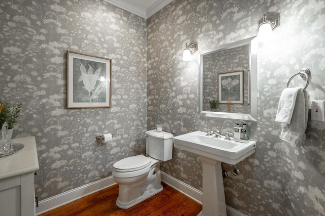 bathroom featuring hardwood / wood-style flooring, ornamental molding, and toilet