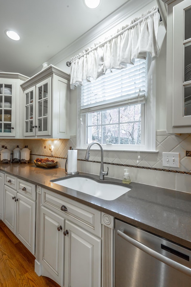 kitchen featuring white cabinets, decorative backsplash, sink, and dishwasher