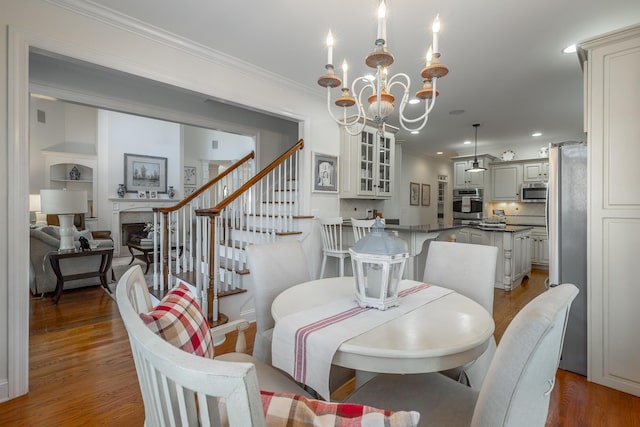 dining area featuring crown molding, dark wood-type flooring, and a chandelier