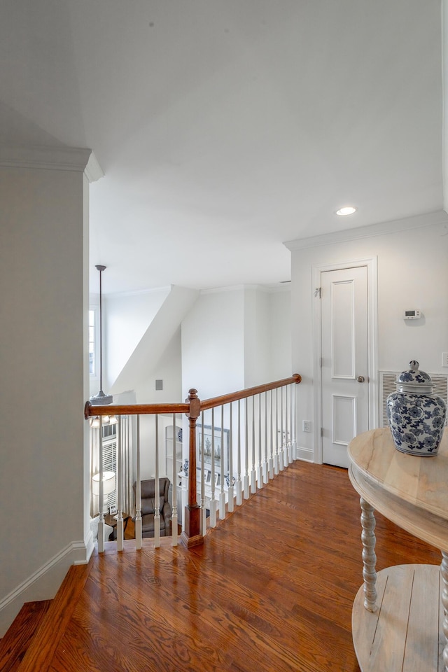 hallway with wood-type flooring and ornamental molding