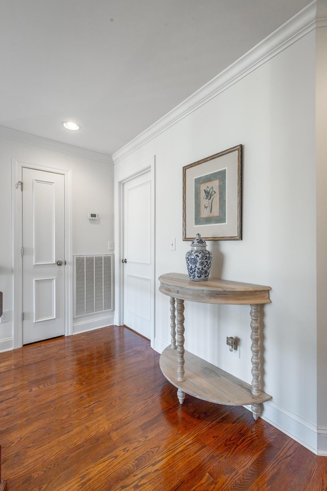 corridor with hardwood / wood-style flooring and ornamental molding