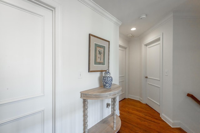 hall with hardwood / wood-style floors and ornamental molding