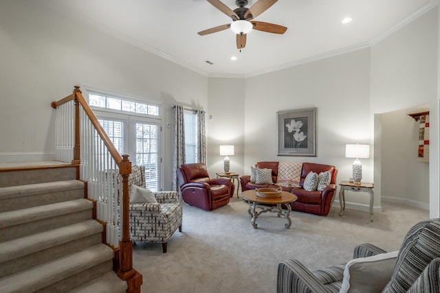 carpeted living room featuring crown molding, ceiling fan, and a high ceiling