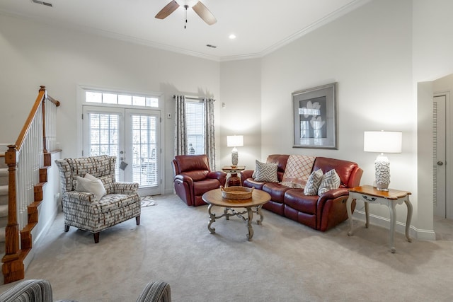 living room with crown molding, french doors, light carpet, and a high ceiling