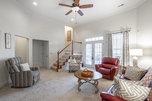 carpeted living room with a high ceiling, crown molding, ceiling fan, and french doors