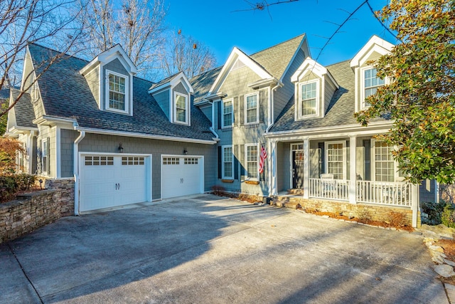 new england style home with a garage and covered porch