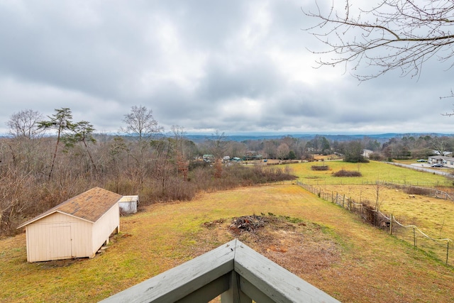 view of yard with a rural view and a storage shed