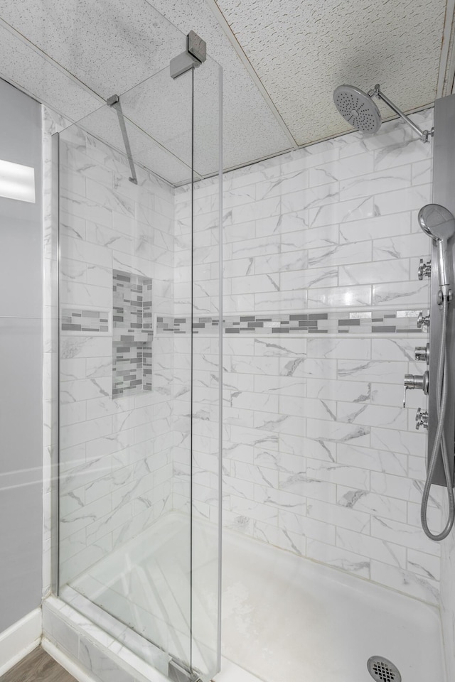 bathroom with an enclosed shower and hardwood / wood-style floors